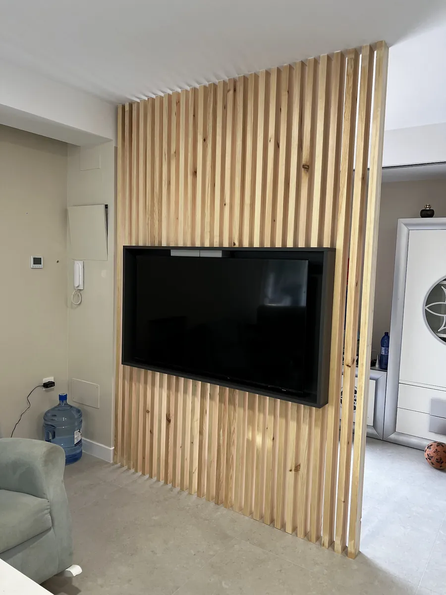 Celosía de listones de madera con soporte para televisión