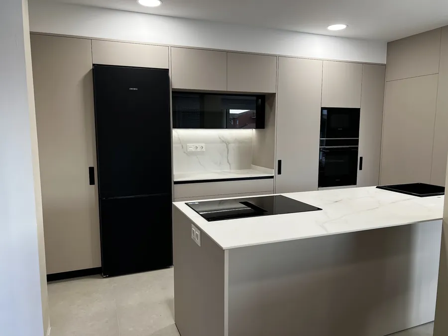 Cocina en gris topo con isla y columnas de electrodomésticos