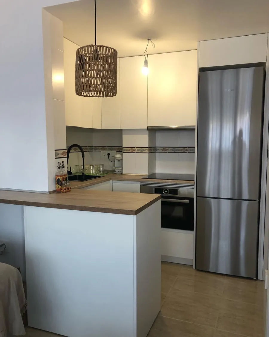 Cocina blanca con península de madera
