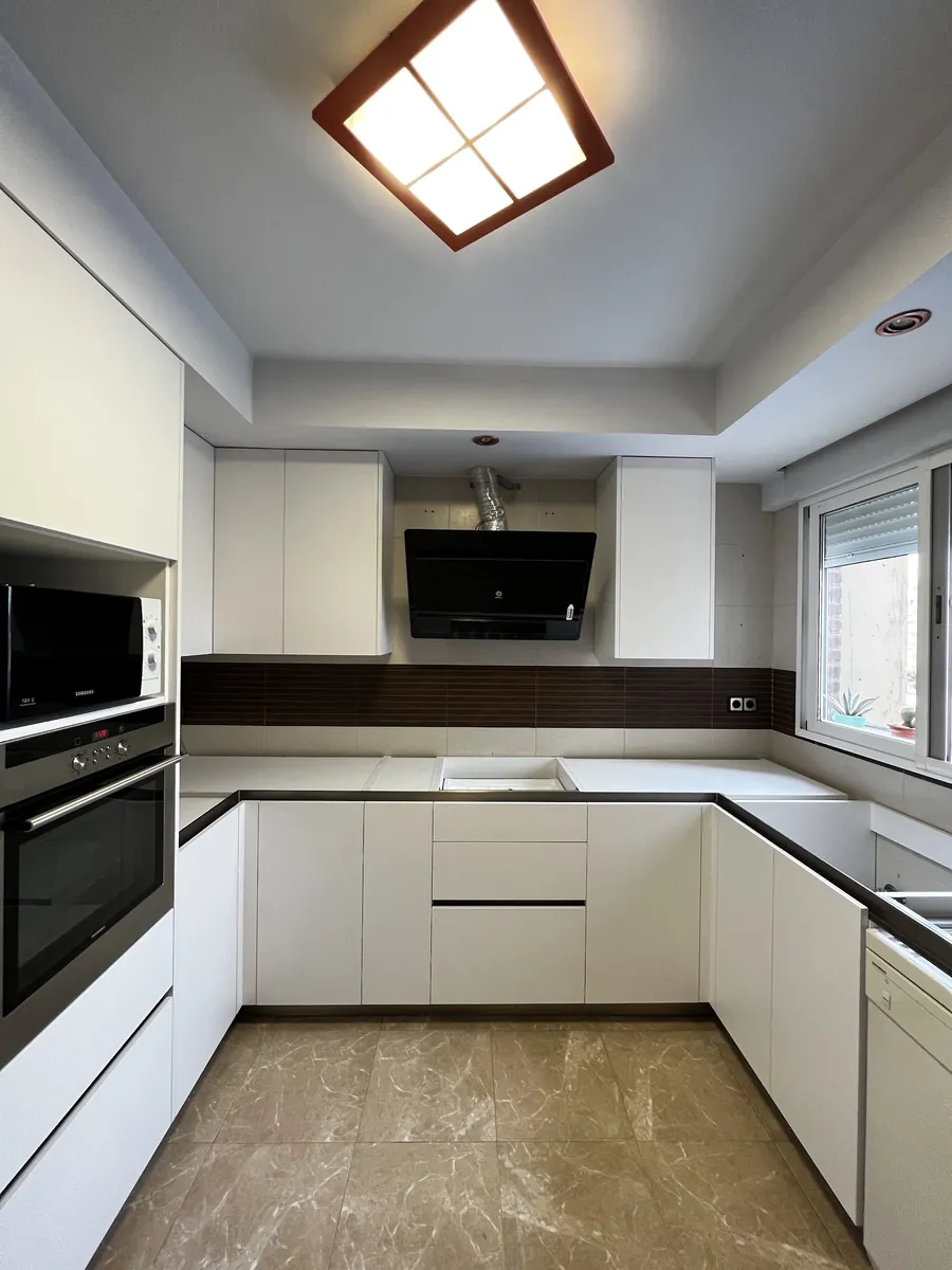 Cocina en U blanca con encimera oscura
